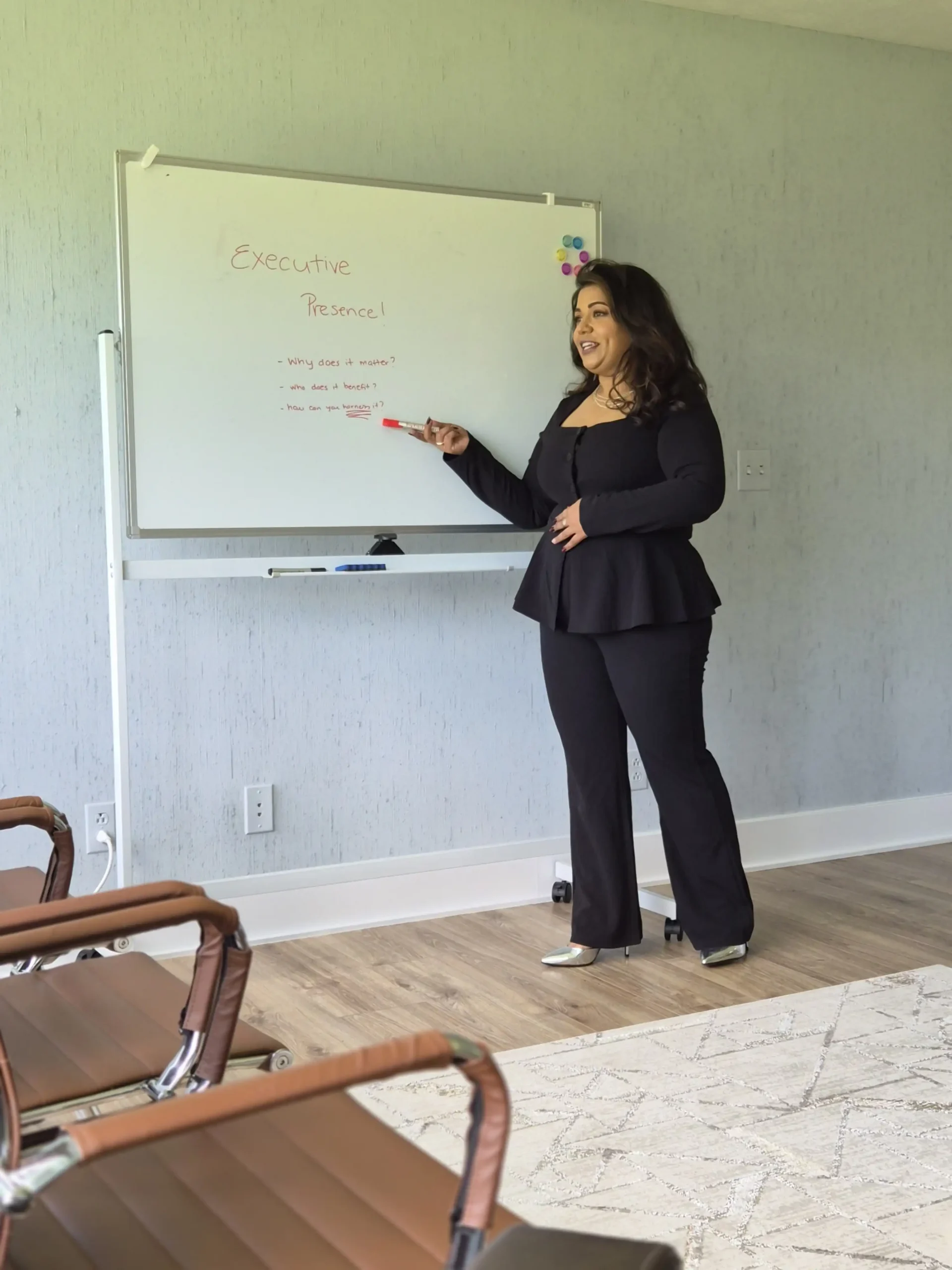 Anam Tareen discussing executive presence beside a whiteboard.