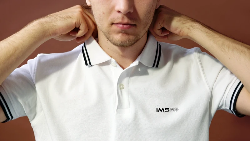 IMS white polo shirt mockup with the wordmark on the chest.