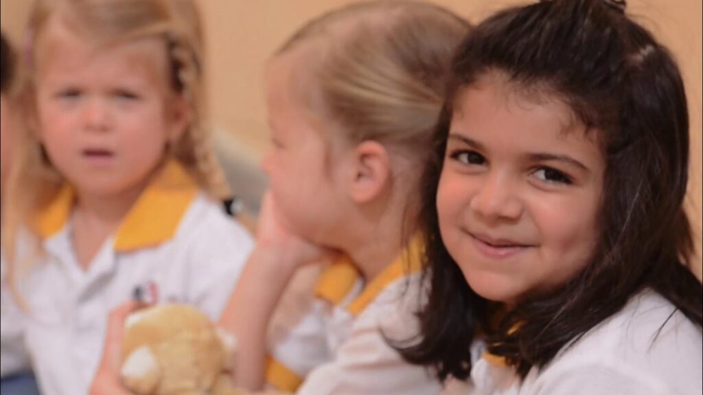 Children in nursery uniforms in a frame from the Step by Step Nursery introduction film.